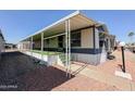 Mobile home exterior showcasing covered patio and landscaping at 652 S Ellsworth Rd # 177, Mesa, AZ 85208