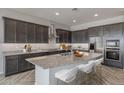 Spacious kitchen with dark cabinetry, granite island, and stainless steel appliances at 19749 S 231 St. Way, Queen Creek, AZ 85142