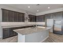 Modern kitchen with dark cabinets, granite countertops, and a large island at 19749 S 231 St. Way, Queen Creek, AZ 85142