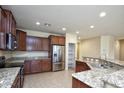 Kitchen with wood cabinets, granite countertops and stainless steel appliances at 21853 N 261St Ave, Buckeye, AZ 85396