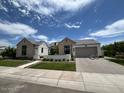Beautiful home with a two-car garage and manicured lawn at 5755 S Joshua Tree Ln, Gilbert, AZ 85298