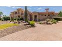 Stunning two-story home with a brick driveway and desert landscaping at 6215 E Turquoise Ave, Paradise Valley, AZ 85253