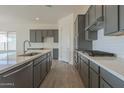 Modern kitchen with gray cabinets, quartz countertops, and stainless steel appliances at 16355 W Desert Mirage Dr, Surprise, AZ 85388