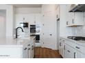 Modern kitchen with white cabinets, quartz countertops, and black faucet at 10010 S 37Th Ave, Laveen, AZ 85339