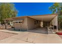 Tan single wide mobile home with covered carport at 8125 E Billings St, Mesa, AZ 85207
