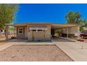 Tan single wide mobile home with covered carport at 8125 E Billings St, Mesa, AZ 85207