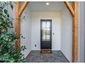 Front entry with a black door, wood beams, and gray tile flooring at 4007 E Montecito Ave, Phoenix, AZ 85018
