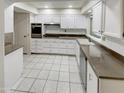 Bright kitchen featuring white cabinets, stainless steel appliances, and tile floors at 9707 W Forrester Dr, Sun City, AZ 85351