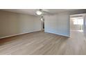 Open living room with wood-look flooring, leading to dining area at 5480 E Boston St, Mesa, AZ 85205