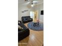 Living room with leather sofas, coffee table, and wood floors at 12413 N El Frio St, El Mirage, AZ 85335