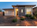 Single story home with stone and stucco exterior at dusk at 11983 W Creosote Dr, Peoria, AZ 85383