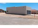 Rear view of a house showcasing stucco exterior and garage at 15941 S Animas Rd, Arizona City, AZ 85123