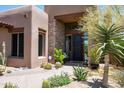 Landscaped front yard with cacti, gravel, and a charming entrance at 9975 E Broken Spur Dr, Scottsdale, AZ 85262