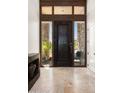 Elegant entryway with a dark wood door, stone accents, and large windows at 9975 E Broken Spur Dr, Scottsdale, AZ 85262