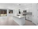 Modern kitchen with white cabinets, island, and stainless steel appliances at 16911 W Siesta Way, Goodyear, AZ 85338