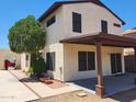 View of house's back with covered patio and a small yard at 4760 W Wahalla Ln, Glendale, AZ 85308