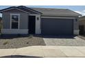 Single-story home with gray siding, stone accents, and a 2-car garage at 40115 W Elm Dr, Maricopa, AZ 85138