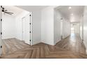 Long hallway with herringbone wood-look tile floors and access to other rooms at 31730 N 169Th Ave, Surprise, AZ 85387