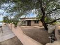 Single-story house with a large front yard and mature trees at 206 2Nd E Ave, Buckeye, AZ 85326