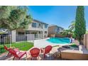 Spacious backyard with a kidney-shaped pool, fire pit, and comfortable seating at 17473 W Elizabeth Ave, Goodyear, AZ 85338