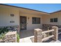 House exterior featuring a brick walkway, security door, and manicured landscaping at 10802 W Cameo Dr, Sun City, AZ 85351