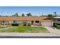 Ranch style home with a two car garage and grassy yard at 10802 W Cameo Dr, Sun City, AZ 85351