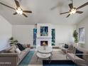 Bright living room with a fireplace, two ceiling fans, and staged furniture at 7417 N Via Camello Del Norte -- # 160, Scottsdale, AZ 85258