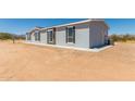 House side view showcasing light gray siding, windows, and backyard at 900 N Windy Meadow Ln, Maricopa, AZ 85139