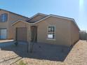 Tan house with brown garage door and small yard at 137 E Douglas Ave, Coolidge, AZ 85128