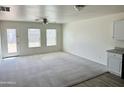 Spacious living room with neutral carpeting and two windows at 137 E Douglas Ave, Coolidge, AZ 85128