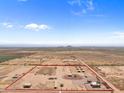 Aerial view of a large equestrian property with a riding arena and paddocks at 48940 W Long Rifle Rd, Aguila, AZ 85320