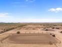 Aerial view of a large property with a riding arena, stables, and paddocks at 48940 W Long Rifle Rd, Aguila, AZ 85320