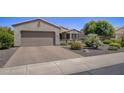 Single-story home with a two-car garage and nicely landscaped front yard at 17780 W Canto Bonito Ln, Surprise, AZ 85387