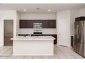 Kitchen with island, stainless steel appliances, and dark brown cabinets at 1951 W Cameron Blvd, Coolidge, AZ 85128