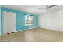 Living room with light teal accent wall and wood-look tile floor at 4222 N 49Th Ave, Phoenix, AZ 85031