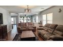 Spacious living room with brown couches, wood coffee table, and wood floors at 6349 W Valencia Dr, Laveen, AZ 85339