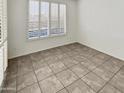 Well-lit bedroom with tile floors and window shutters at 9186 W Clara Ln, Peoria, AZ 85382