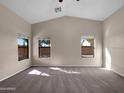 Spacious carpeted bedroom with three windows and a ceiling fan at 42054 W Cheyenne Dr, Maricopa, AZ 85138