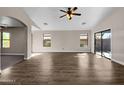 Living room featuring wood-look flooring, sliding glass doors, and high ceilings at 42054 W Cheyenne Dr, Maricopa, AZ 85138