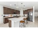 Modern kitchen featuring a large island, stainless steel appliances, and dark cabinetry at 4455 W Suncup Dr, San Tan Valley, AZ 85144