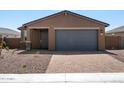 New single-story home with gray garage door and brick paver driveway at 4351 W Janie St, San Tan Valley, AZ 85144