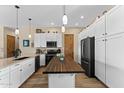 Kitchen with island, white cabinets, and stainless steel appliances at 1085 Yaqui Dr, Wickenburg, AZ 85390