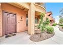 Brown front door entrance with stonework and landscaping at 21655 N 36Th Ave # 104, Glendale, AZ 85308