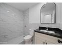 Updated bathroom features a walk-in shower, marble tile, and modern vanity at 632 N 72Nd Pl, Scottsdale, AZ 85257