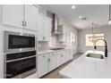 White kitchen with stainless steel appliances, quartz countertops, and modern black faucet at 16348 W Avenida Del Sol --, Surprise, AZ 85387