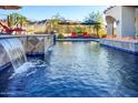 Stunning pool with waterfall, fire pit, and lounge chairs at 9233 S Krista E Dr, Goodyear, AZ 85338