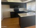 Modern kitchen with dark cabinetry, granite countertops, and hardwood floors at 4327 E San Gabriel Ave, Phoenix, AZ 85044