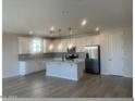 Modern kitchen with island, stainless steel appliances, and white cabinetry at 11522 S 50Th Ln, Laveen, AZ 85339