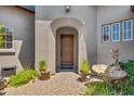 Front entrance of the home with a wooden door and brick walkway, featuring a fountain at 8874 E Flathorn Dr, Scottsdale, AZ 85255