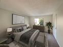 Main bedroom with a king-size bed and modern decor at 10828 N Biltmore Dr # 203, Phoenix, AZ 85029